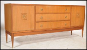 A 1970's retro teak wood sideboard of low and wide form being raised on tapered with a bank of