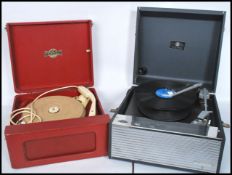 A vintage mid 20th century red vinyl portable three speed  record player by Micrograli together with