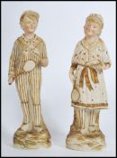 A figural group of 2 early 20th century continental bisque slip moulded tennis figures, one a boy,