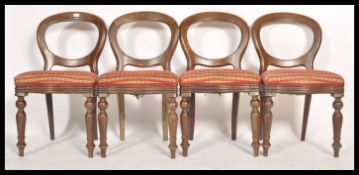 A set of 4 Victorian style balloon back dining chairs being raised on turned legs with overstuffed