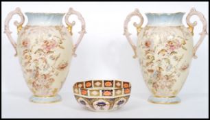 A large pair of Victorian Stafforshire twin handles vases having ivory blush grounds with floral