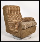 A retro 20th century circa 1970's swivel armchair upholstered in the original fabric and set over