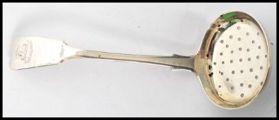 A 19th century Georgian silver hallmarked caddy spoon tea strainer in the fiddle pattern having a