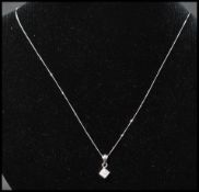A 9ct gold and diamond pendant necklace strung with a diamond pave set pendant  on a white gold