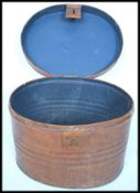 A Victorian tin hat box - luggage chest with hinged top, scrumble finish and latch to the front.