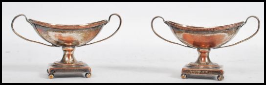 A pair of Georgian 19th century twin handles silver plated table salts, raised on pedestal plinth