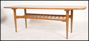 A Danish inspired mid century teak wood rectangular coffee table being raised on tapered legs with