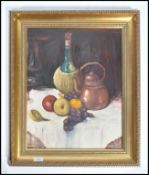 A framed 20th century oil on canvas still life painting depicting fruit at the foot of a brass