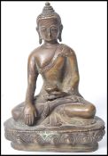 A 19th century Oriental Chinese bronze Buddha modelled in the lotus position holding a pot raised on