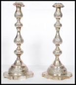A large pair of Edwardian silver hallmarked London tall candlesticks with shaped terraces and shaped