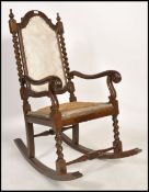 An early 20th century Carolean revival mahogany rocking chair / armchair raised on barley twist