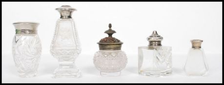 A collection of vintage early 20th century cut glass perfume / atomizer bottles many with silver