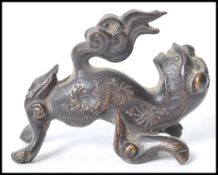 A 19th century Chinese bronze figurine of a temple lion dog of Fu having a flaming tail. Measures