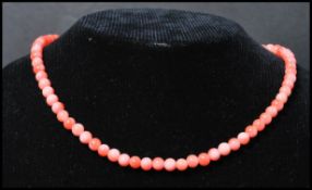 A vintage angel skin coral necklace. Each bead carved and strung set to a gilt barrel clasp.