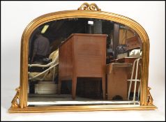 A Victorian style large dome top overmantel mirror of arched form having plinth base, gilded resin
