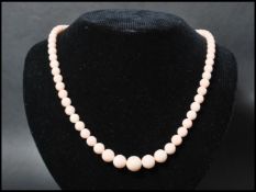 A vintage bleached coral necklace. The necklace of graduating form each bead carved and strung set