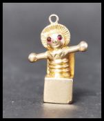 A 9ct gold Jack In The Box charm having ruby stone eyes. Unmarked but tests as 9ct gold, eyes test