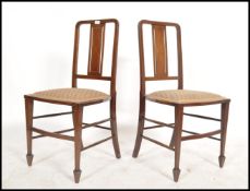 A pair of Edwardian mahogany inlaid bedroom chairs being raised on square tapered legs with