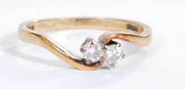 A hallmarked 9ct gold and diamond crossover ring set with two diamonds of approx 10pts each.