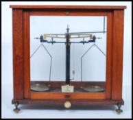 A pair of early 20th century mahogany cased scientific scales. The glass case with inset scales on