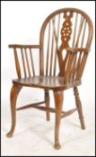 A good early 20th century wheelback windsor armchair raised on cabriole legs having beech and elm