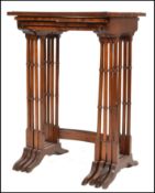 An Edwardian mahogany quartetto nest of tables being raised on faux bamboo supports with splayed
