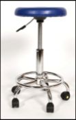 A contemporary chrome and plastic operators - surgical chair. The blue plastic swivel seat over
