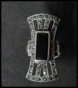 A large 925 silver Art deco style ring set with marcasite and central onyx lozenge. weight 10.8g.