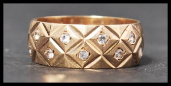 A hallmarked 9ct gold and white stone band ring set with twenty two points white stones. Size O