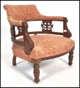 A late Victorian mahogany tub chair - armchair being raised on turned legs with overstuffed seat and