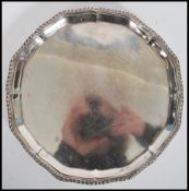 A silver hallmarked salver raised on claw and ball feet bearing London hallmarks, date letter e