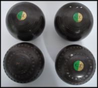 A set of four vintage 20th century Lignum Vitae lawn bowls, applied makers plaque to all.