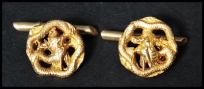 A pair of vintage 18ct gold Chinese cuff links in the form of Chinese dragons with bamboo t bars.