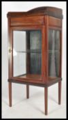 A mahogany 20th century bijouterie upright pedestal display cabinet raised on squared legs with