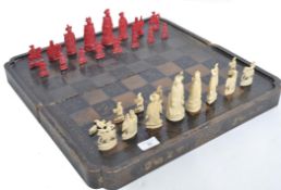 A 19th century Chinese - Canton carved ivory chess set in natural and stained red colourway complete
