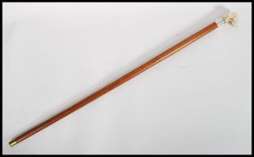 A vintage 20th century walking stick cane. The tapering wooden shaft having a silver stamped