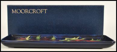 A Moorcroft ceramic pin tray of rectangular form tube lined decorated with flowers in the Anemone