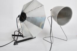 A non matching pair of vintage up cycled 20th century photographic lamps, both being converted