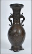 A Meji period Japanese bronze two handled vase of typical baluster form, decorated in relief with