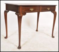 A Victorian style mahogany writing table raised on pad feet with cabriolet legs with leather gilt