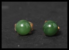 A pair of vintage 9ct gold and jade stud earrings. Jade stone beads set to gold post backs. Weighs