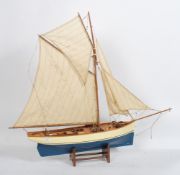 A vintage 20th century scratch built model of a sailing boat raised on the original wooden display