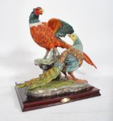 A large hunting interest figural group depicting a brace of pheasants set to a naturalistic base