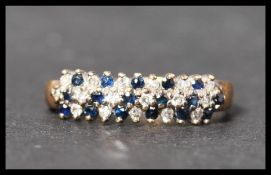 A hallmarked 9ct gold sapphire and diamond cluster ring. Hallmarked London. Weight 2.6g. Size N.