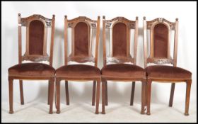 A set of 4 Edwardian high back mahogany dining chairs in the Arts & Crafts style being raised on