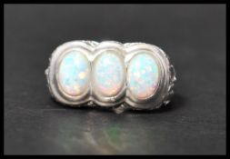 A contemporary 925 silver 3 stone cocktail / dress ring being set with oval opal cabochon stones