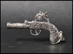 A 925 silver novelty pendant in the form of an ornate pistol with bale. Marked London 1795 Sterling.