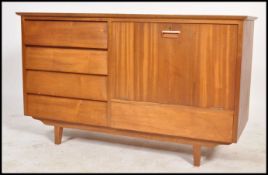 A 1970's retro teak wood Danish influence sideboard being raised on tapering legs with a bank of