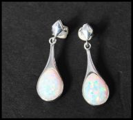 A pair of 925 silver opal pear shape drop earrings having a pierced style setting with post backs.