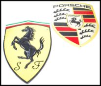 A vintage style cast metal point of sale advertising wall plaques for Ferrari and Porsche both